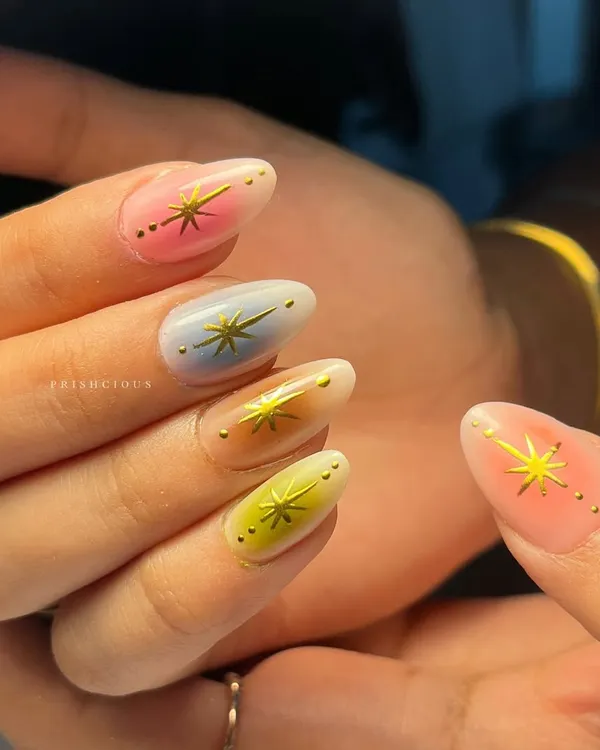 A close-up of these multi-color aura nails. Each nail has a different pastel base with a soft white aura effect, making them look like they're glowing from within.