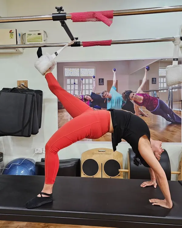 This is what peak control and strength looks like on the Cadillac. This inverted position challenges the entire body, requiring core stability, back flexibility, and focused breathing to achieve this beautiful line.
