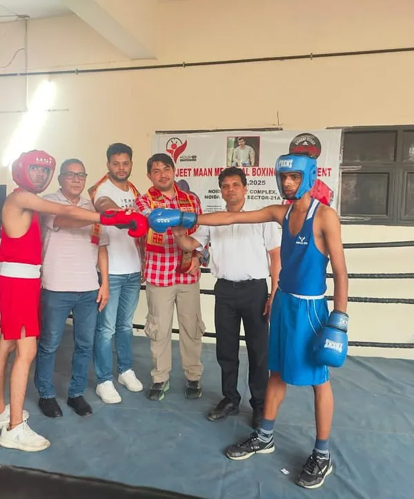 Two young fighters ready for a bout at the Jeet Maan Memorial Boxing Tournament, with officials present. This is a formal competitive environment where they apply their training.