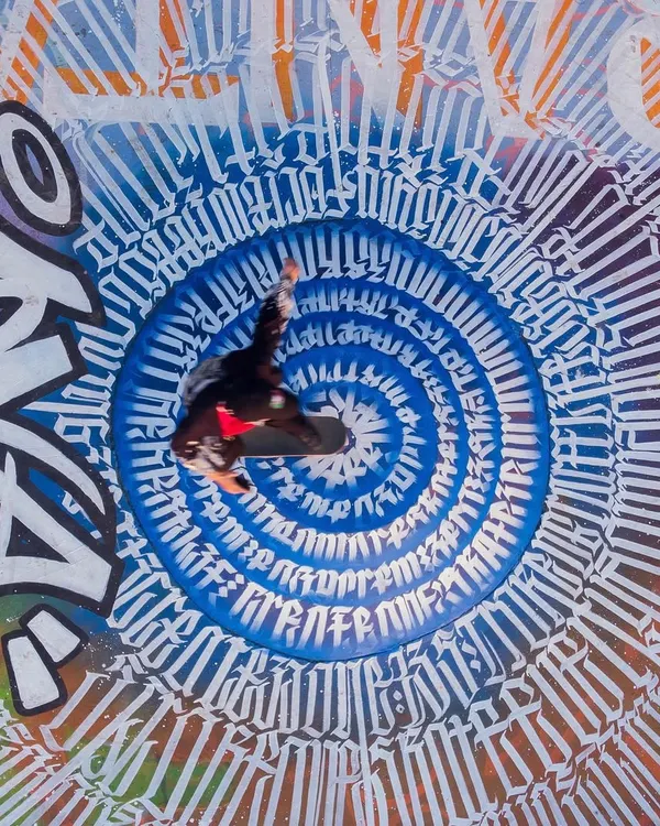 An overhead shot of a skater mid-air, perfectly centered in the calligraffiti vortex I designed for the Carter Road Skatepark project. This piece was the heart of a massive collaboration, blending street art with skate culture.