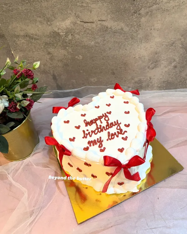 I love making these vintage-style heart cakes. This one features delicate buttercream piping, tiny red hearts, and elegant red ribbons, creating a timeless look for a special birthday. It’s a beautiful way to express your love with a classic design.