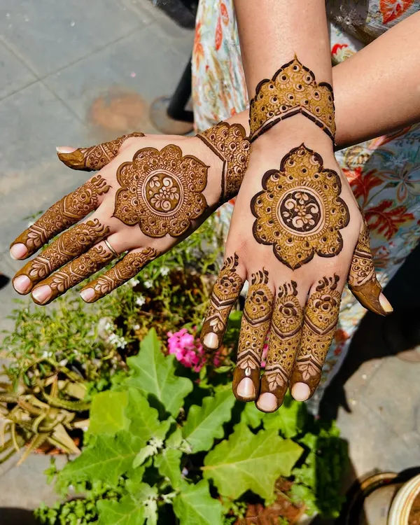 A beautiful and sunny shot of a modern mandala design. The patterns on each hand are different but complementary.