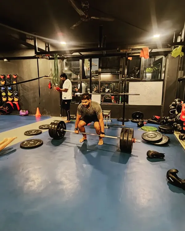 The deadlift is a fundamental test of strength. Here, a client is in position for a heavy lift, surrounded by the tools of our trade. We build strength from the ground up.