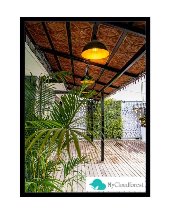 This image highlights the ambient lighting and ceiling detail of a covered terrace I designed. The warm pendant lights illuminate the wooden deck below, while a vertical garden and privacy screen in the background add layers of texture and greenery to the overall design.