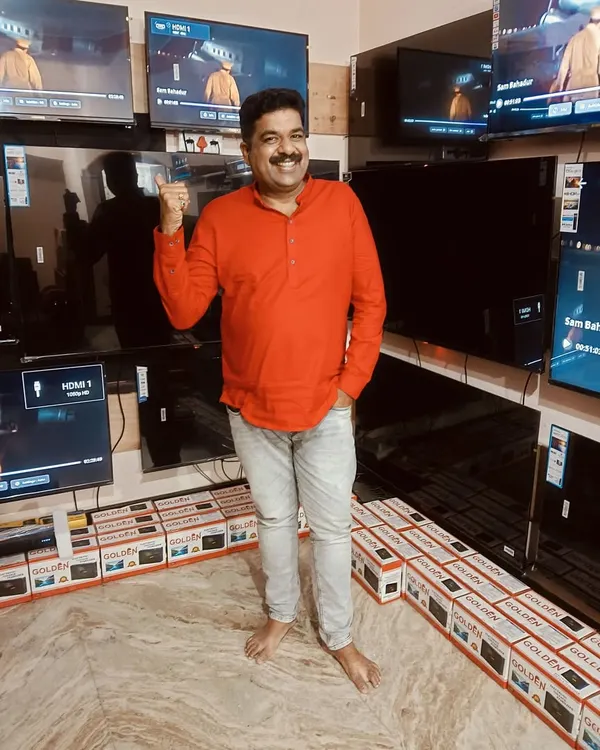 At my friend's Golden TV shop in Nagarabhavi, surrounded by the latest models. I was there to help promote his business. It's a great feeling to support a friend's venture.
