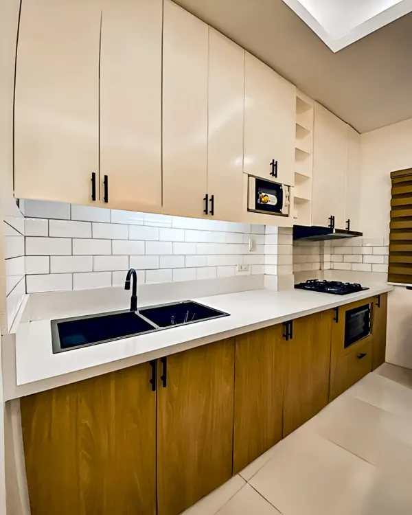A sleek parallel kitchen combining natural wood grain on the lower cabinets with clean white overhead storage. This design maximizes a narrow space, offering ample counter area and a modern look with its white subway tile backsplash.