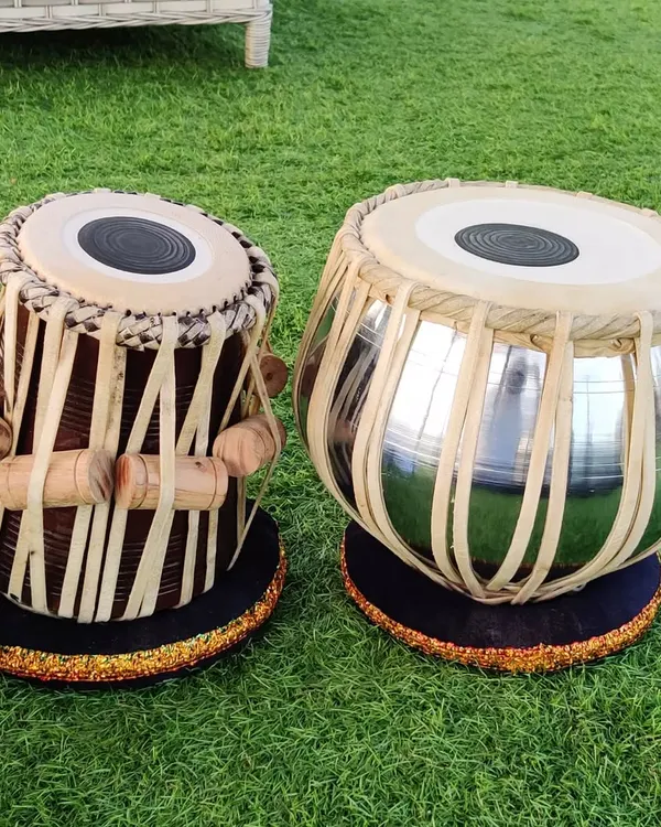 This professional tabla set, featuring a chrome-finished bayan, is ready for delivery. We ensure every pair, like this one set on our lawn, meets high standards for performance and durability.