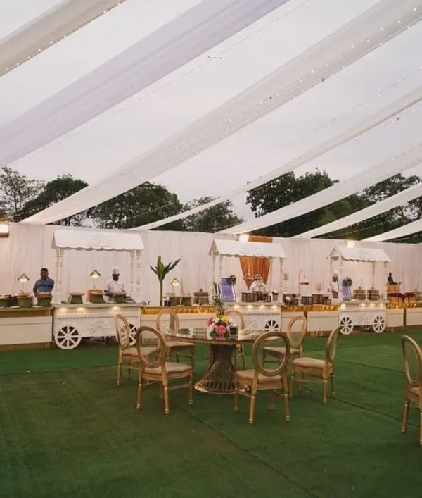 Serving style, flavor, and flair. A wide view of our outdoor catering setup, featuring elegant white food carts and guest seating on a lush green lawn.