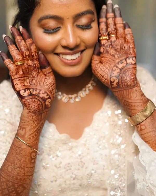 A smiling bride showing off her beautiful, dark henna stain. My goal is always to create bridal henna that brings joy and makes you feel amazing on your wedding day.