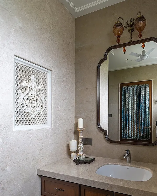 In this Hyderabad home, we used a handcrafted lattice panel, or *jaali*, to divide the shower and dry areas in the bathroom. This traditional element, rooted in Indian and Middle Eastern architecture, adds a beautiful, functional detail that balances minimalism with a love for craft.