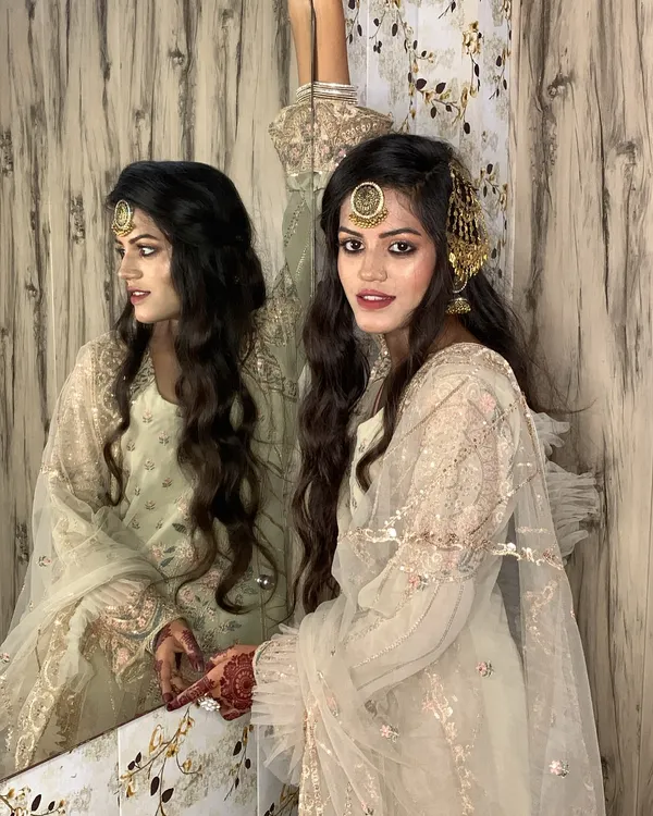 This is the kind of timeless elegance I love to create for special occasions. The look features soft, flowing waves, complemented by a traditional maang tikka and passa, paired with makeup that enhances her natural beauty for a radiant glow.
