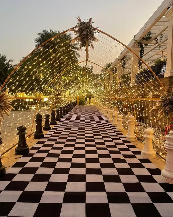 We believe every great party starts with a grand entrance. This unique chess-themed walkway, illuminated by a tunnel of fairy lights, created an unforgettable first impression for guests arriving at this evening celebration.