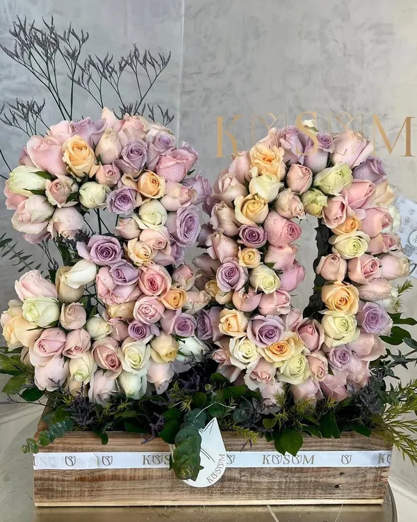 I call this "Dreamland." For an 80th birthday, I created these floral numbers using a glorious mix of lavender, baby pink, peach, and white roses, all composed in one of my signature rustic wooden boxes.