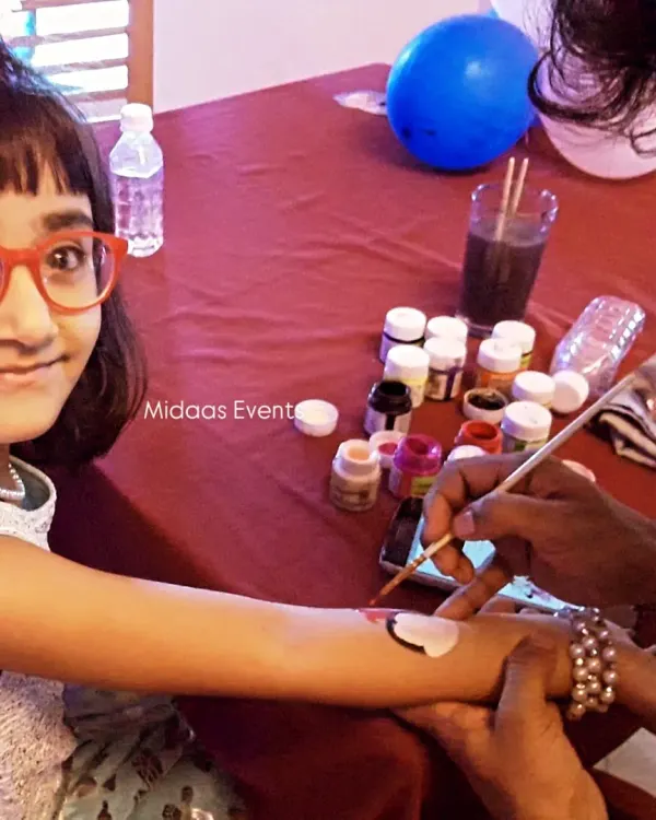 This young guest is all smiles as she gets her arm painted at the temporary tattoo stall. I hire professional and friendly artists who are great with children, ensuring a safe and fun experience for everyone.