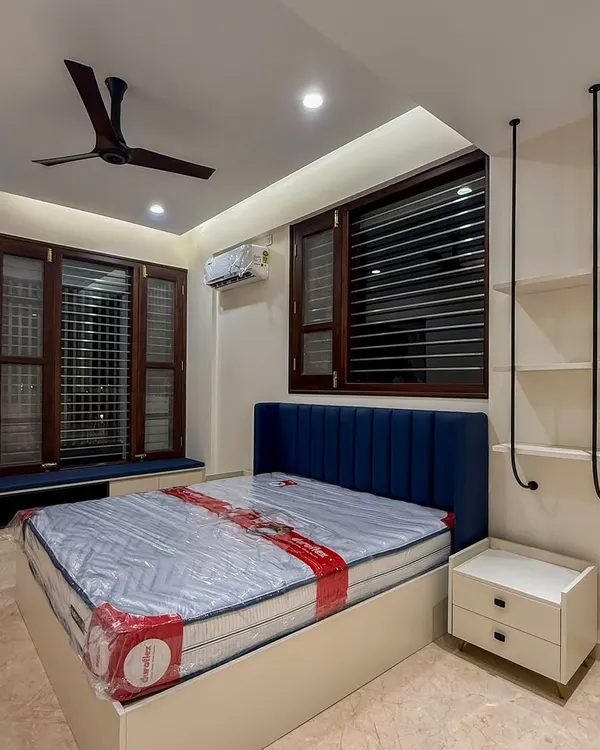 This kid's bedroom is designed to grow with the child. The calming navy headboard creates a perfect environment for focused play and restful sleep, while the unique hanging shelves add a touch of modern fun.