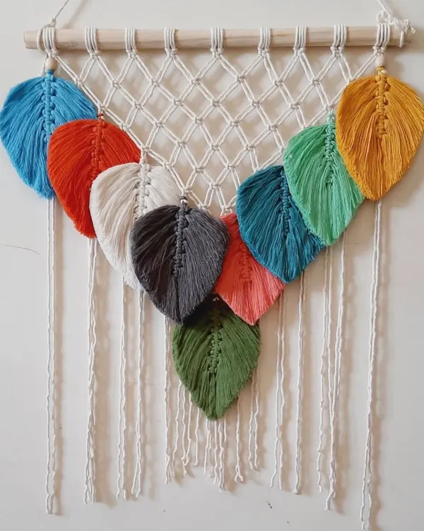 This wall hanging is a beautiful showcase of my macrame leaves. It features a cascade of leaves in many different colors, creating a vibrant and natural look.