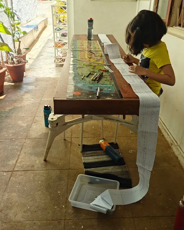 A child works on a long timeline, gluing paper upon paper to map out vast stretches of history. This kind of "big work" allows her to physically grasp the scale of time and connect different historical events in a meaningful way.