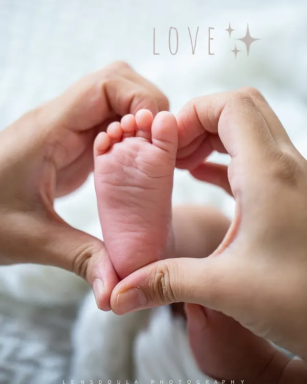 There is so much love in the smallest details. Parents' hands forming a heart around their newborn's tiny foot is a simple, powerful image of family love.