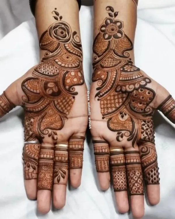 A classic Arabic mehandi design, featuring bold floral and paisley patterns that flow diagonally across the hands.