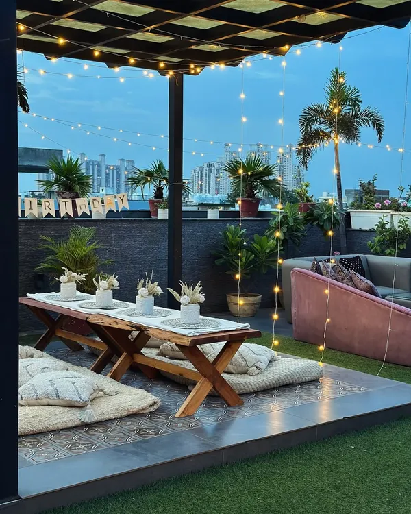 A soulful sunset view from my Gurugram rooftop. This boho-chic picnic setup with low wooden tables and floor cushions is perfect for a relaxed and intimate gathering with friends.
