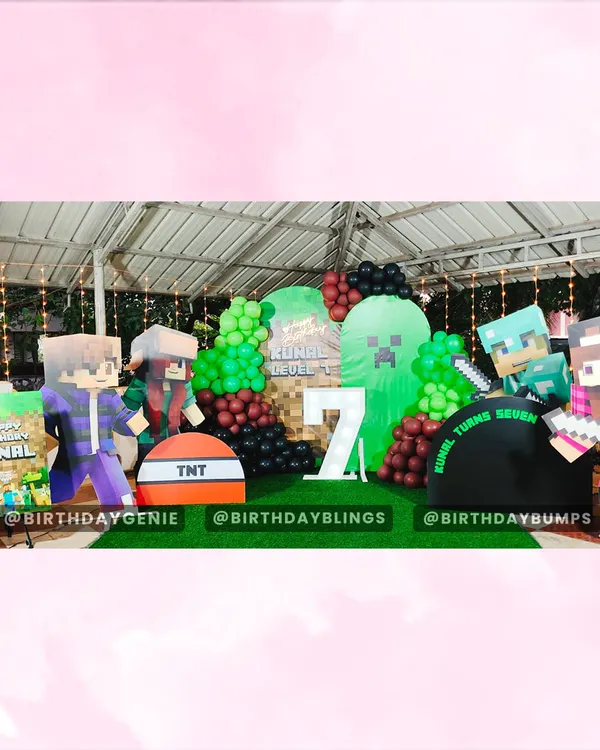 A full stage setup for a Minecraft 7th birthday party. The scene includes multiple character cutouts, a Creeper backdrop, TNT props, and a light-up number '7', all set on artificial grass to complete the look.