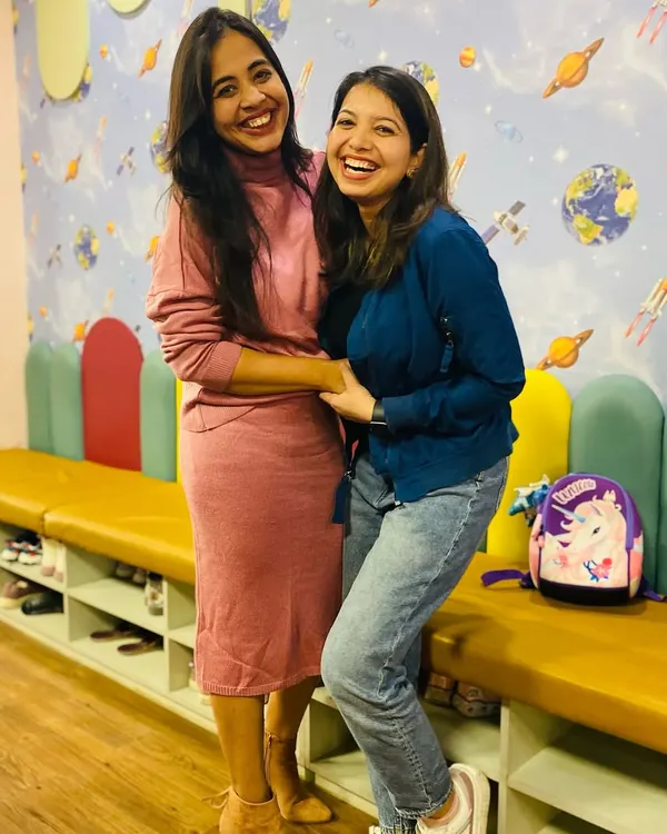 Happy moms make happy kids! Two mothers share a laugh at our café while their children enjoy the play area.