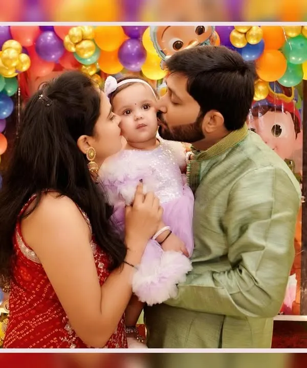 A baby's first birthday is a milestone for the whole family. We focus on capturing these loving, candid family portraits, like this tender kiss from mom and dad, creating a memory that will be cherished for a lifetime.