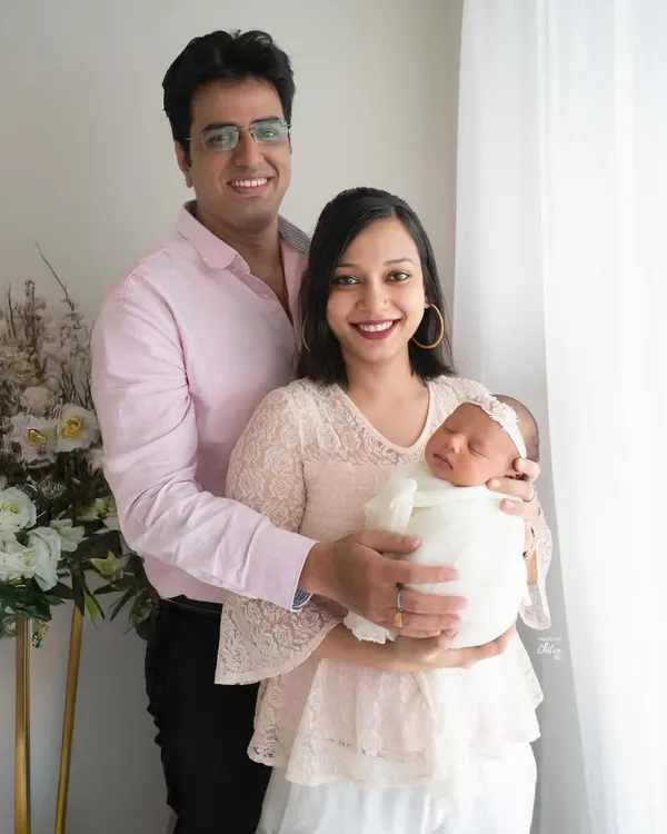 A beautiful first family portrait. I use soft, natural light from the window to create a bright and airy feel, highlighting the peaceful joy of new parenthood.