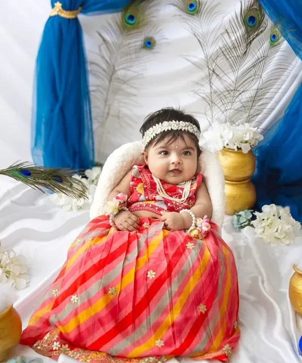 My heart is so full looking at this little Radha. Her colourful lehenga and sweet smile are just perfect against the backdrop of peacock feathers and royal blue drapes.