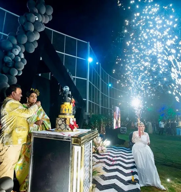 A wide shot of the cold pyro display during a 60th birthday cake cutting. The sparks create a brilliant fountain of light, perfectly framing the couple and making the moment feel spectacular.