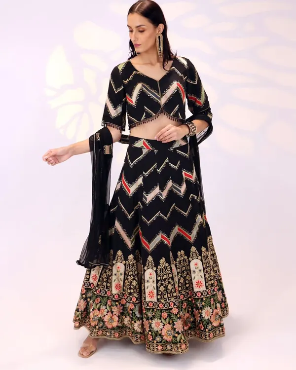 This is one of my favorite creations, a black georgette lehenga that feels both regal and modern. The design features a striking chevron pattern on the skirt, which is balanced by a beautifully detailed floral border with intricate hand embroidery. It’s an outfit designed to make a graceful statement at any grand celebration.