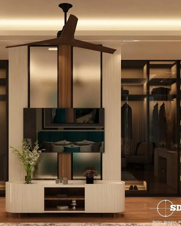 A luxurious master bedroom featuring a custom TV unit that doubles as a partition for a walk-in closet. The design uses fluted panels and a mix of wood and white finishes for a sophisticated, modern look.
