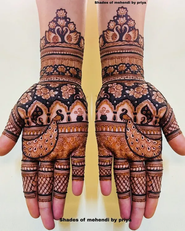 A classic full bridal mehendi with matching designs on both hands. This pattern features graceful swans and peacocks, along with traditional jharokha architecture.