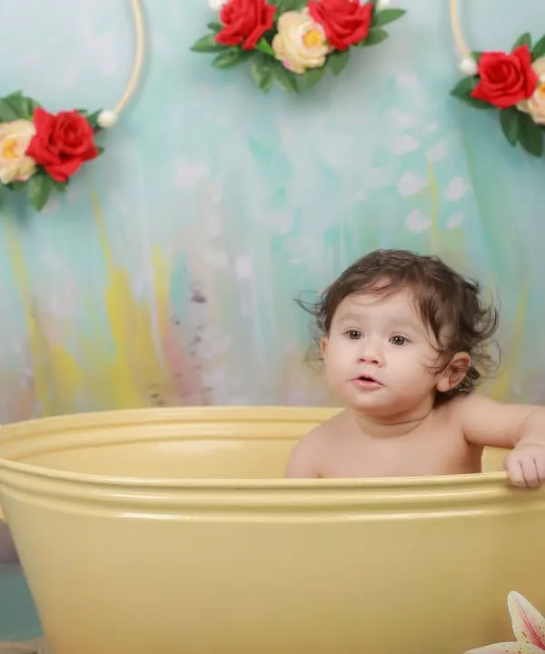A curious look from a baby in a yellow tub. Our splash sessions are a great way to capture your child's inquisitive nature in a fun, playful setting.