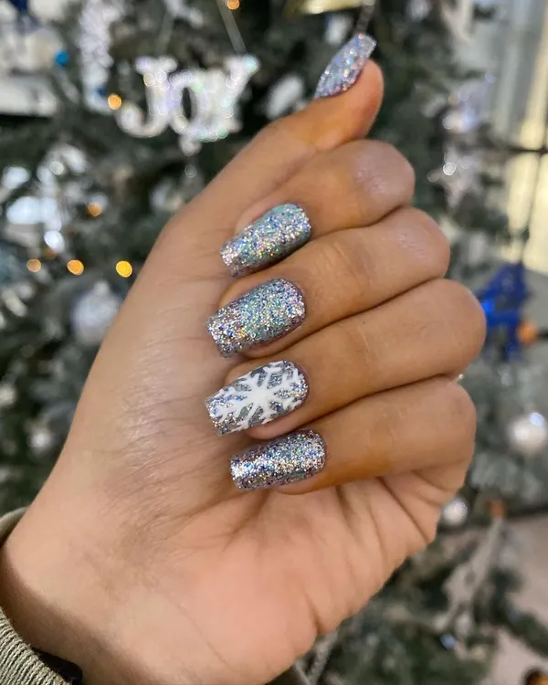 Get into the holiday spirit with this Christmas-themed set. It features full-coverage silver glitter with a white accent nail showcasing a delicate, hand-painted snowflake.