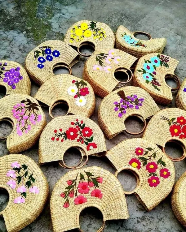 A vibrant collection of our handcrafted bags, each woven from natural fibers and adorned with unique floral embroidery. This showcases the beautiful artistry and variety our skilled artisans bring to every piece, making each bag a one-of-a-kind fashion statement.
