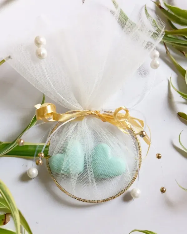 A beautifully finished wedding favor featuring two mint-green, heart-shaped soy wax melts. Packaged with a golden bangle and delicate tulle, it's a memorable gift for guests, fully customizable for your event.