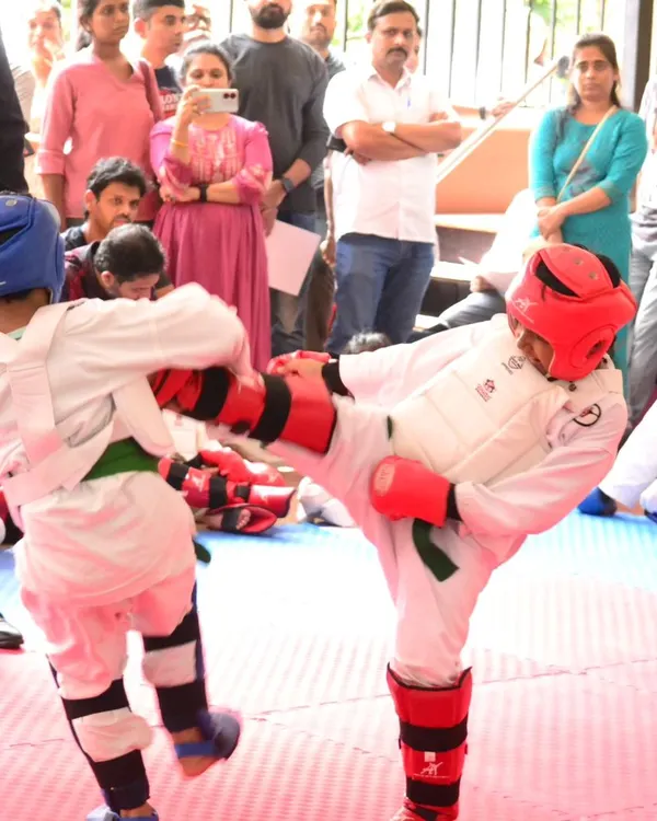 A young student demonstrates focus and power, executing a precise kick during a kumite match. This is what our competition coaching is all about: building the skill and confidence to perform under pressure.