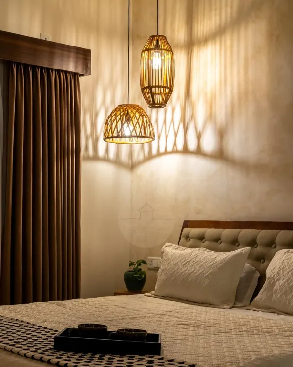This cozy master bedroom shows the transformative power of lighting. The rattan pendant lights cast beautiful shadows on the textured wall, turning the space into a magical and intimate retreat at night.