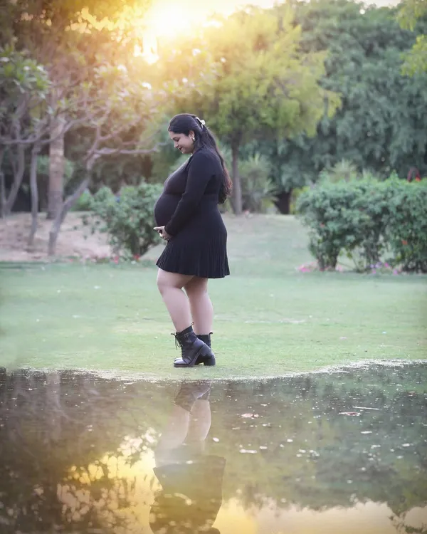 Two reflections, one soul. This artistic outdoor shot uses the water's reflection to mirror the miracle of motherhood, all set against the warm glow of the setting sun.