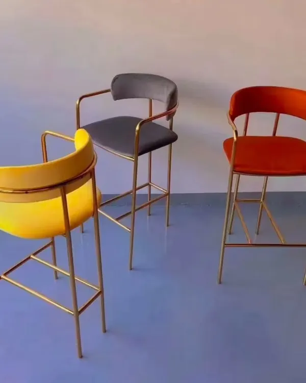 These high counter chairs feature a sleek gold-plated frame and are available in multiple colors like yellow, grey, and orange. They add a touch of modern glamour to any bar area.