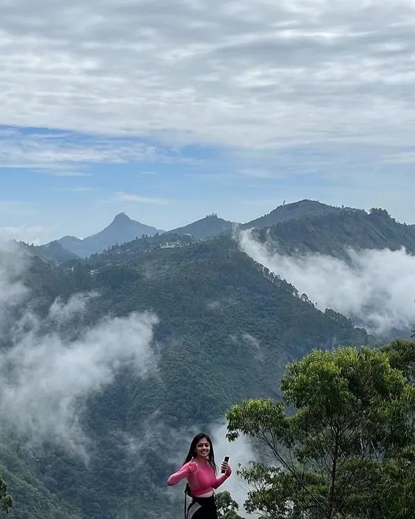 The view from the top in Kodaikanal is always worth the hike. Here's a traveler enjoying the stunning landscape of rolling hills blanketed in mist.