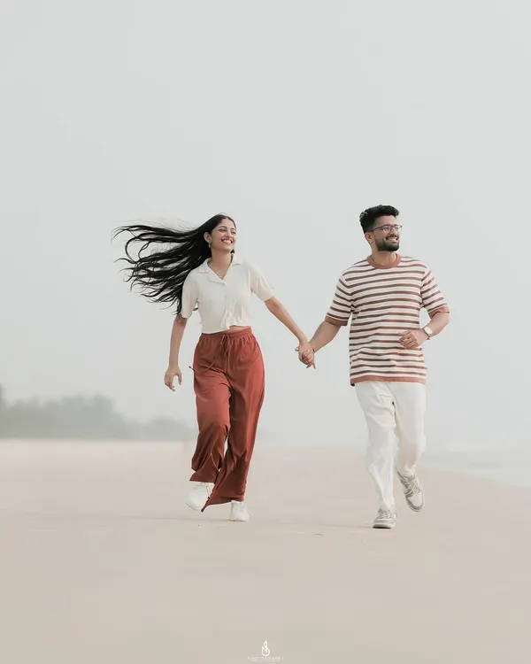 A joyful run along the beach, with her hair flying in the wind. This kind of energetic, candid shot perfectly captures a couple's fun-loving spirit.