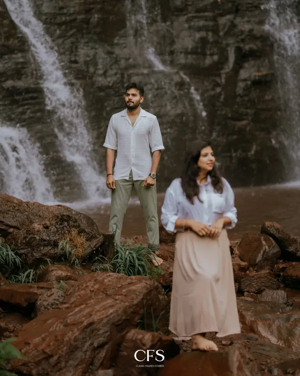A quiet moment of reflection for the couple against a stunning waterfall backdrop. This shot emphasizes the grandeur of nature and the peaceful connection between two people.