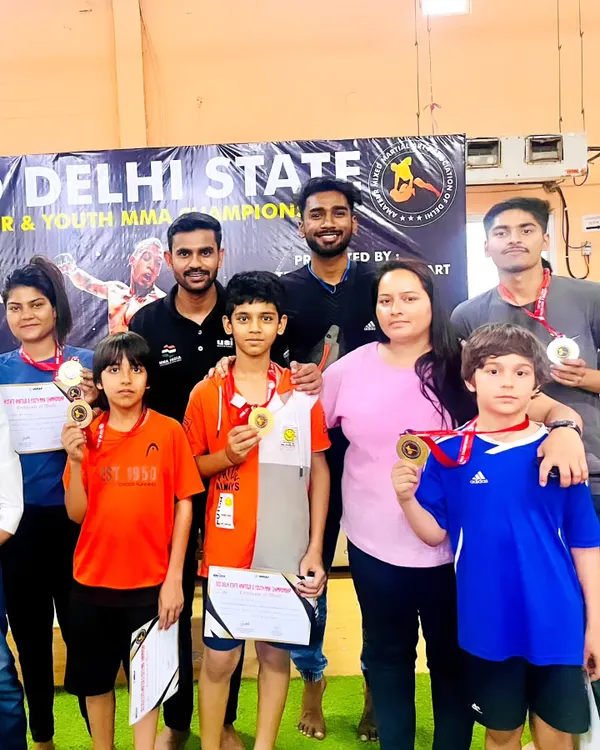 Our team celebrating a big win at the Delhi State MMA Championship 2024. We brought home 8 gold medals, 1 silver, and 1 bronze, along with the first prize trophy. This picture shows the joy and pride of our young champions and their coaches.