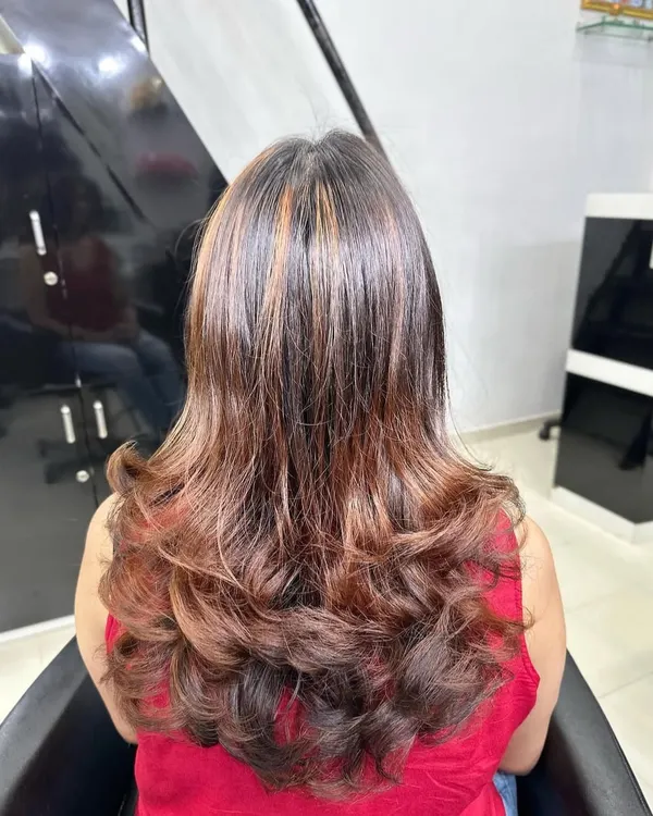 A beautiful example of copper brown hair highlights. I styled it with layered curls at the end to add volume and show how the light catches the different warm tones in the hair.