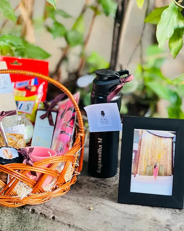 A beautiful farewell gift basket for a valued colleague. This hamper includes a personalized water bottle, a photo frame, and a collection of their favorite snacks and wellness items.