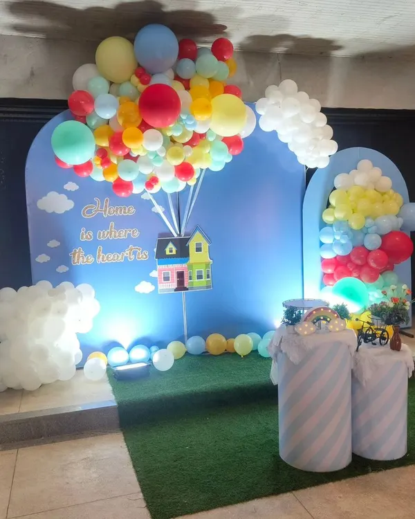A whimsical housewarming party theme inspired by the movie "Up," with a balloon-lifted house prop.