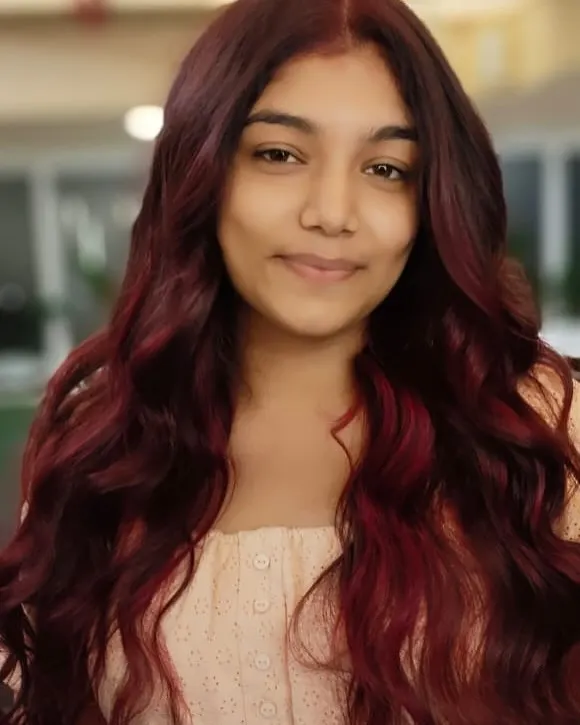A vibrant red hair transformation that radiates confidence. This look was achieved with careful color application and styling to create soft, beautiful waves.