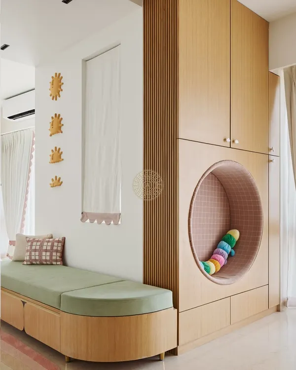 This reading nook is one of my favorite features in this girls' room. The wardrobe includes a cozy, circular cutout perfect for curling up with a book, and the long green bench provides extra seating and storage.